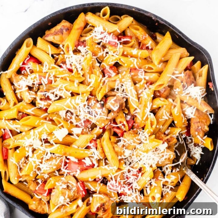 A cast iron skillet with one pot chicken pasta in it