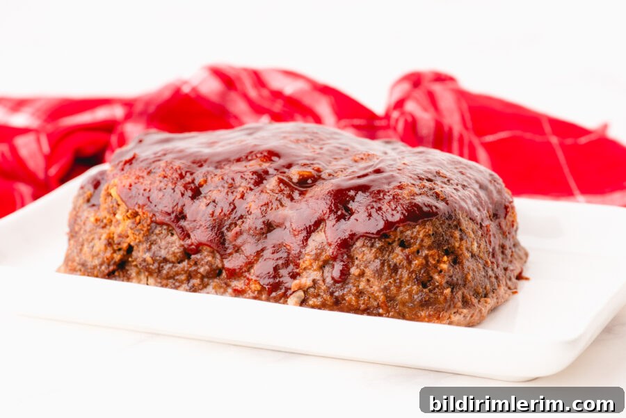 Classic Lipton Onion Soup Meatloaf Recipe for Comforting Dinners 2 Lipton Onion Meatloaf with ketchup glaze on a platter ready to be cut and served.