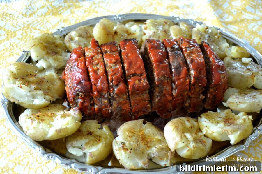 Crispy Smashed Potatoes Recipe with Garlic and Herbs 7 Platter of sliced meatloaf surrounded by smashed potatoes
