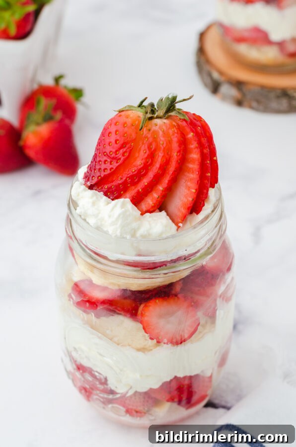 Finished jar dessert topped with a sliced strawberry