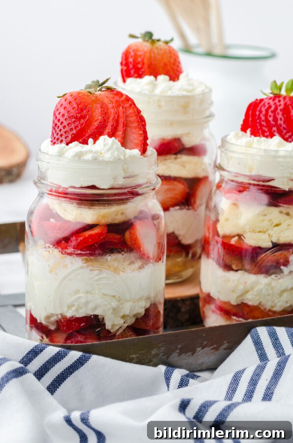 Strawberry shortcakes in a jar assembled and on a tray for serving.