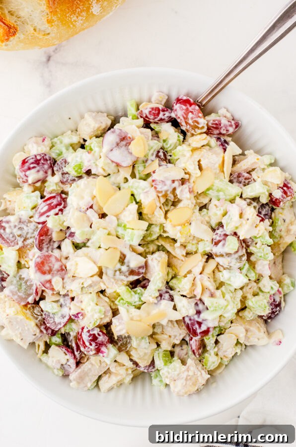 A bowl of chicken salad topped with sliced almonds
