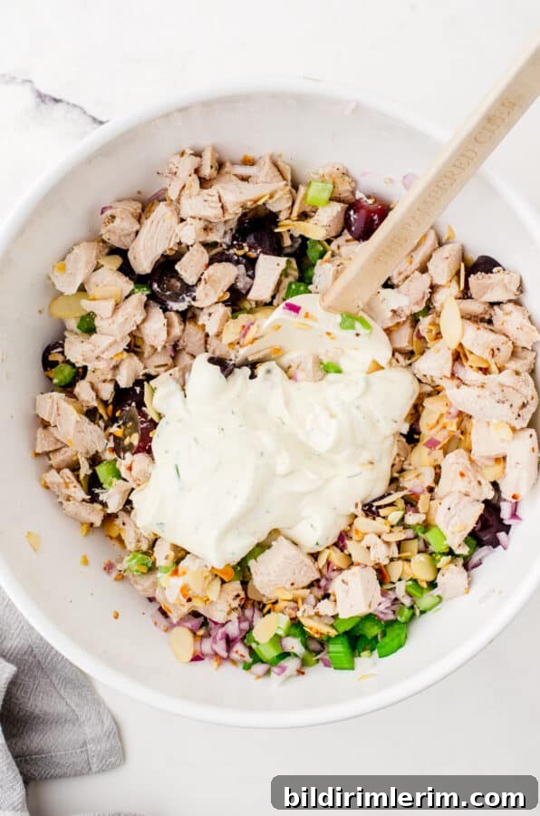 Dressing being added to chicken salad