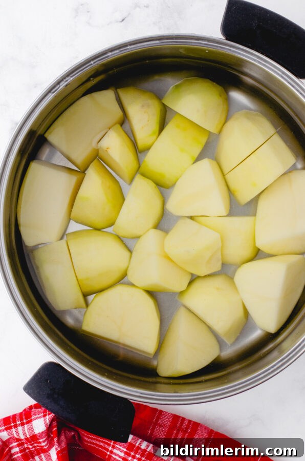Creamy Whipped Mashed Potatoes with Cottage Cheese 4 Peeled potatoes in a pot covered with water.