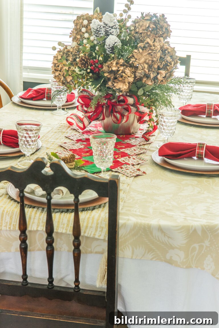A christmas table set with red napkins and a large centerpiece
