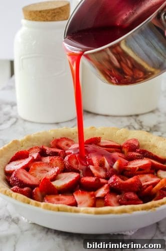 Strawberry Jello Pie Recipe with Grandma's No-Roll Crust 11 strawberry pie glaze being poured onto strawberry pie.