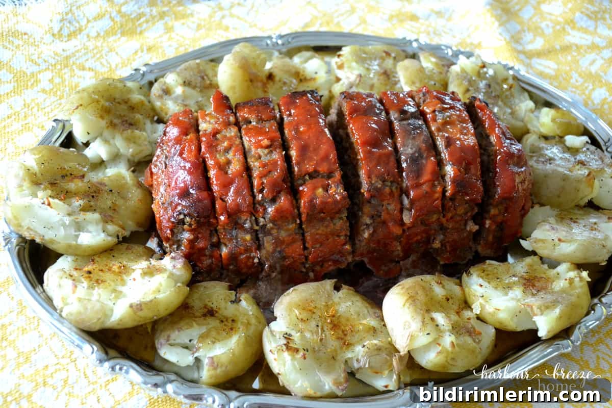 Homemade meatloaf recipe with homemade barbecue sauce topping with smashed potatoes on a large serving platter.